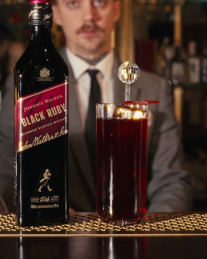 The finished Cherry Lady with its disco ball pick, next to a bottle of Black Ruby